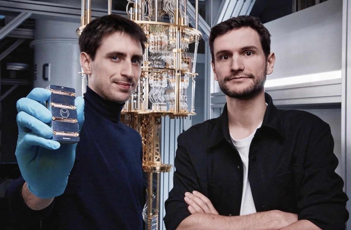Deux cofondateurs d’une startup française présentent un processeur quantique dans un laboratoire équipé d’un cryostat, illustrant les avancées technologiques d’Alice & Bob dans le domaine de l’informatique quantique.